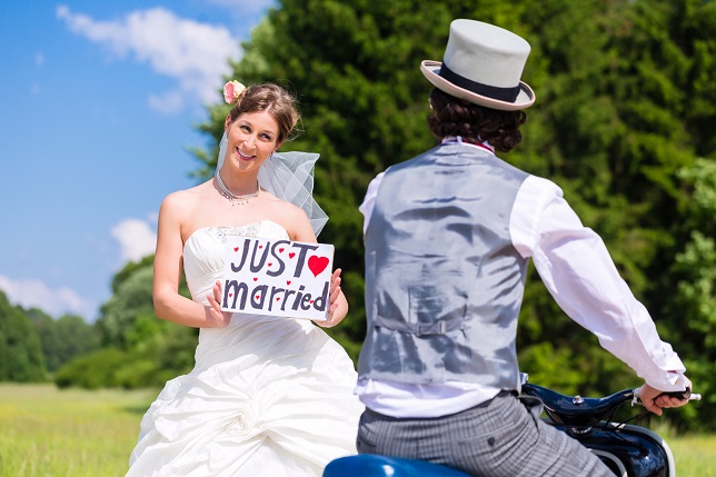 Wedding groom pick up bride with motor scooter having fun