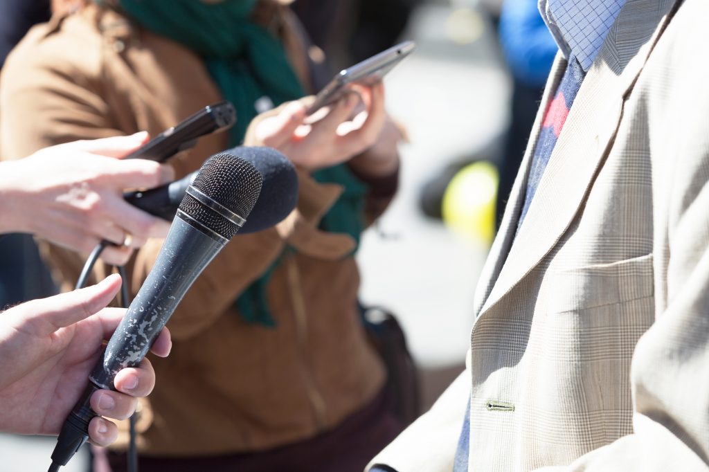 Reporter holding a microphone conducting an media interview